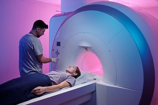 “Paciente a entrar numa máquina de ressonância magnética num ambiente clínico, ilustrando o contexto da claustrofobia e da ansiedade associada ao exame.”